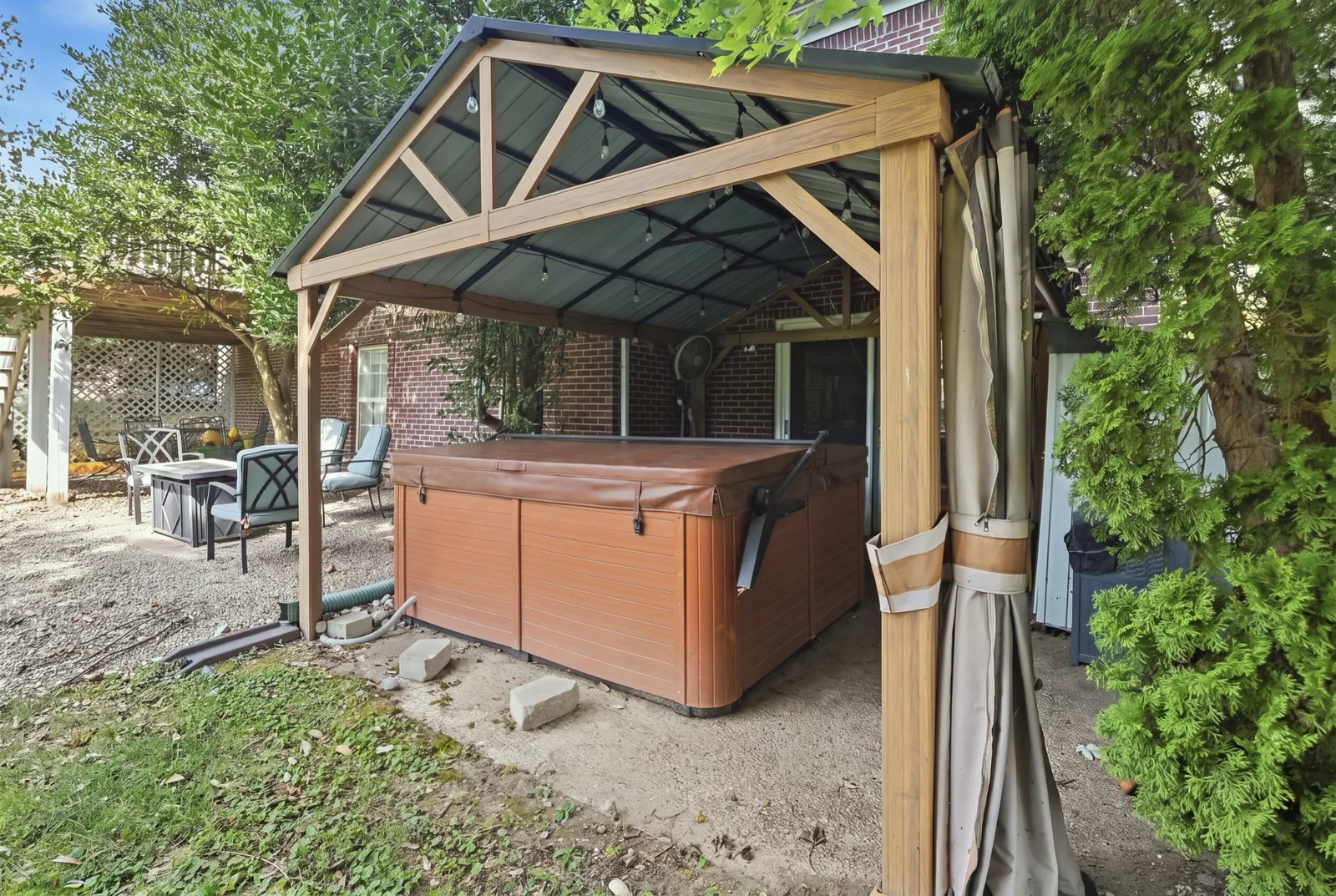 The hot tub under a pergola on the lower patio