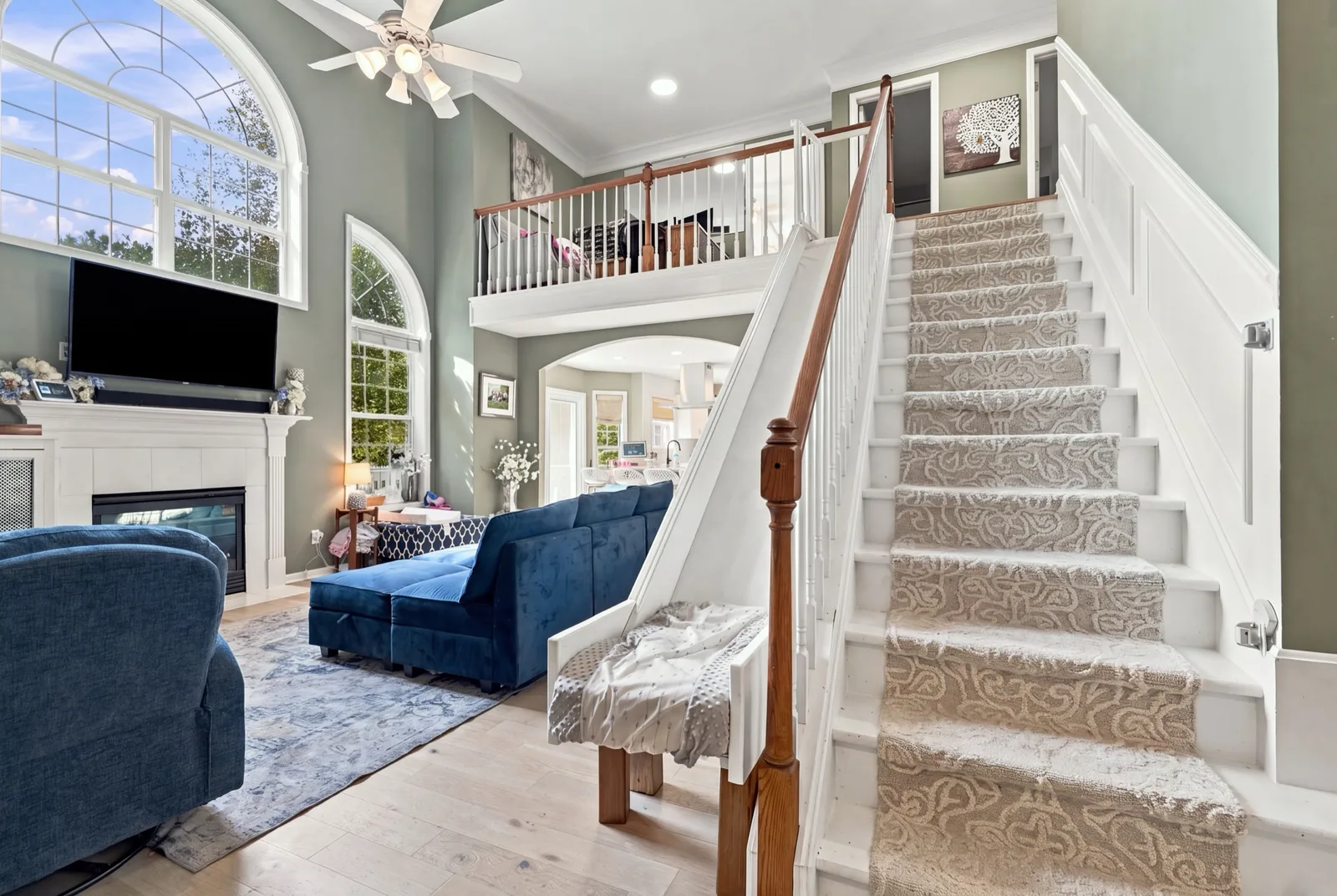 The two-story living room. A white custom slide runs down beside the staircase to a cushioned landing.